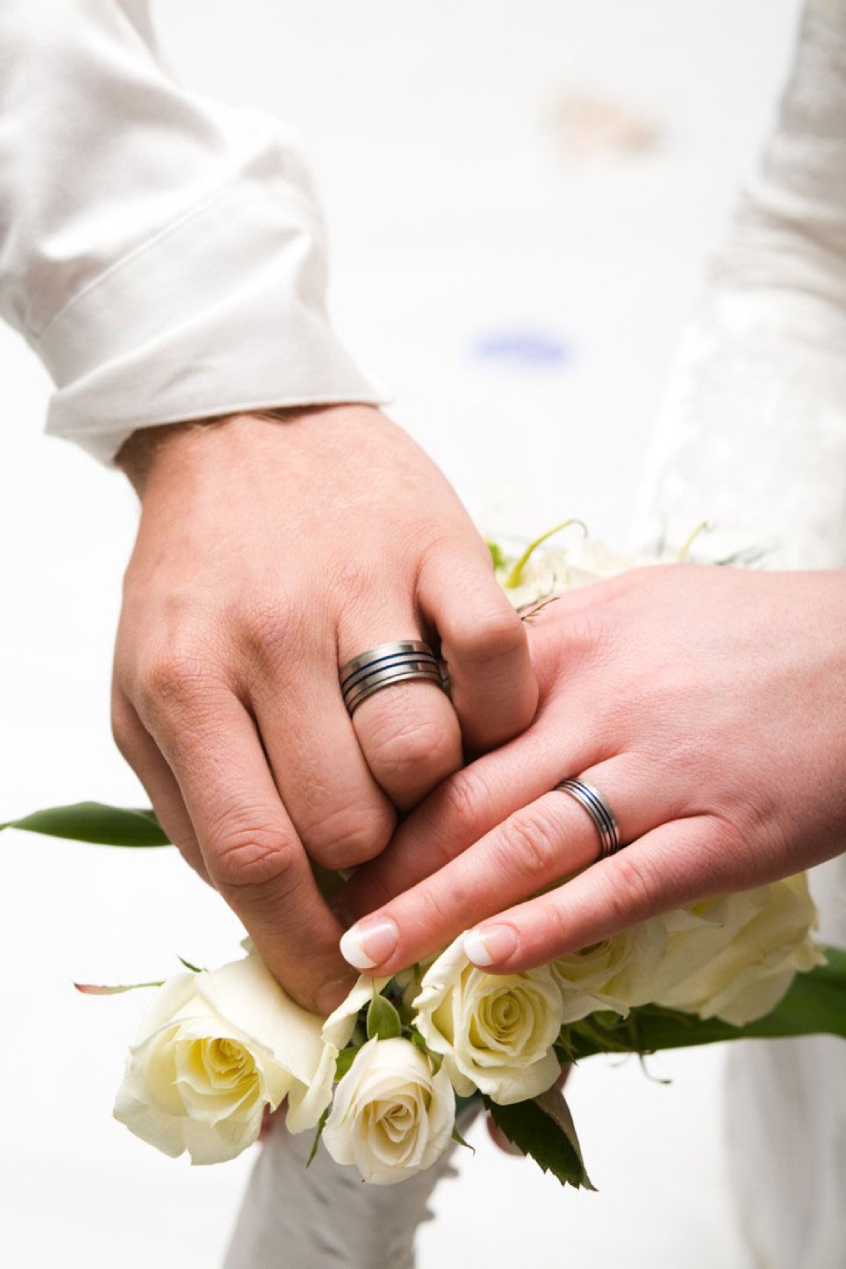 Wedding rings and white roses close-up